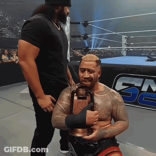 A Man In A Wrestling Ring Holds A Lantern In Front Of A Gm Logo GIF