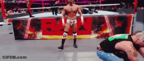 A Man In A Wrestling Ring Stands In Front Of A Sign That Says ' Wwe ' GIF