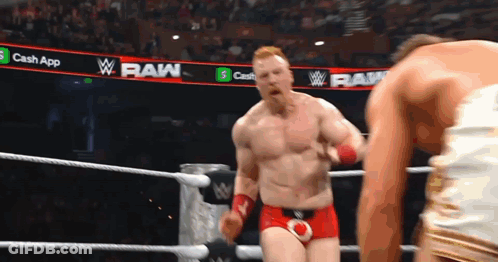 A Man In A Wrestling Ring With A Banner That Says Raw On It GIF