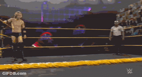 A Man In A Wrestling Ring With A Referee Behind Him And # 20 On The Screen GIF