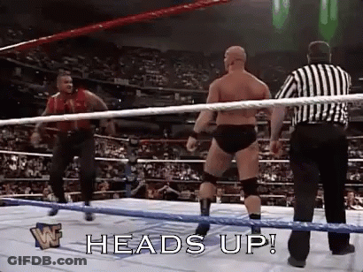 A Man In A Wrestling Ring With A Referee Standing Behind Him . GIF