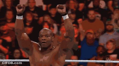A Man In A Wrestling Ring With His Arms In The Air GIF