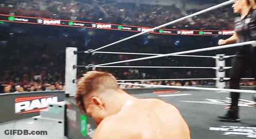 A Man In A Wrestling Ring With The Word Raw On The Wall GIF