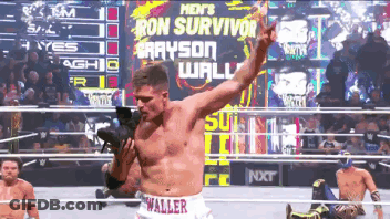 A Man In A Wrestling Ring With The Words Ron Survivor On The Screen Behind Him GIF