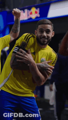 A Man In A Yellow Adidas Shirt Is Holding A Trophy GIF