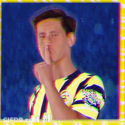 A Man In A Yellow And Blue Shirt Has His Finger To His Mouth And The Word Nitesine.com Is On His Sleeve GIF