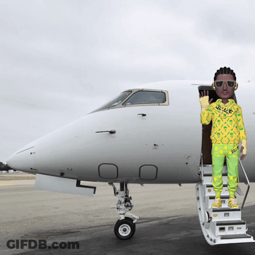 A Man In A Yellow And Green Outfit Is Standing On The Stairs Of A Private Jet GIF