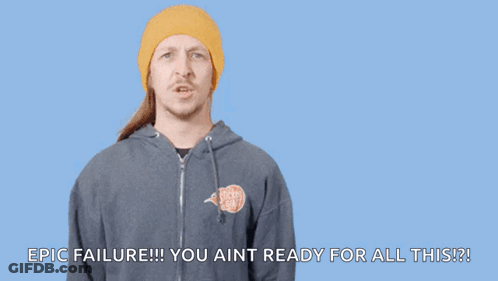 A Man In A Yellow Beanie Is Pointing At His Head With The Words " You Had One Job " Written Above Him GIF