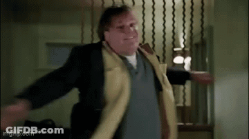 A Man In A Yellow Coat Is Dancing In A Room . GIF