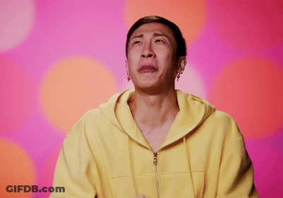 A Man In A Yellow Hoodie Is Crying With His Hands Folded In Front Of His Face GIF