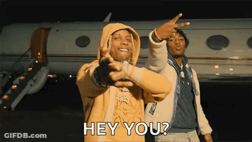A Man In A Yellow Hoodie Is Pointing At Another Man In Front Of An Airplane And Says Hey You GIF