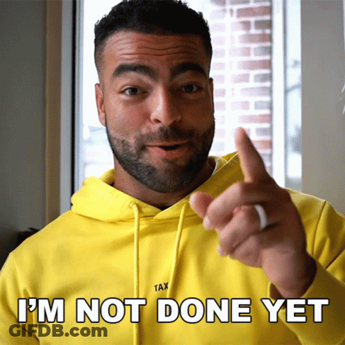 A Man In A Yellow Hoodie Says " I 'M Not Done Yet " While Pointing GIF