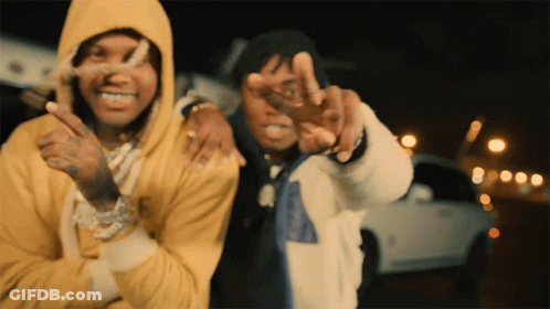 A Man In A Yellow Hoodie Stands Next To Another Man GIF
