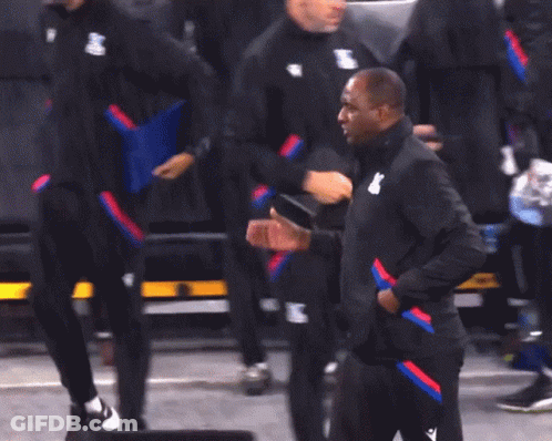 A Man In A Yellow Hoodie Talks To Another Man In Black Jackets GIF