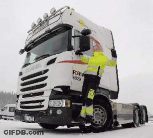 A Man In A Yellow Jacket Climbs Up The Side Of A Forna Truck GIF
