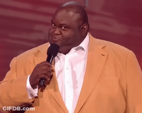 A Man In A Yellow Jacket Holding A Microphone GIF