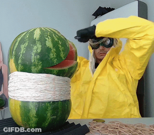 A Man In A Yellow Jacket Is Cutting A Watermelon With A Knife GIF