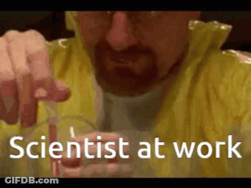 A Man In A Yellow Jacket Is Holding A Beaker With The Words Scientist At Work Written On It GIF
