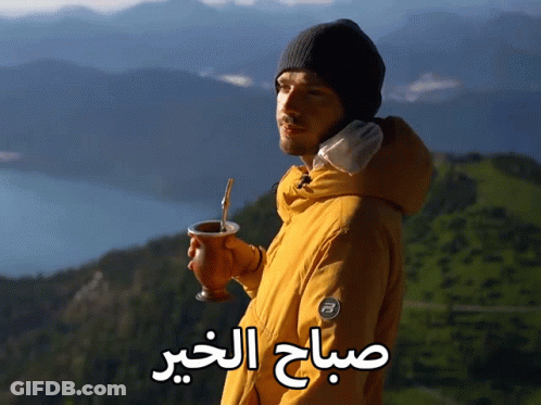 A Man In A Yellow Jacket Is Holding A Cup With A Straw And The Words " صباح الخير " Written On The Bottom GIF