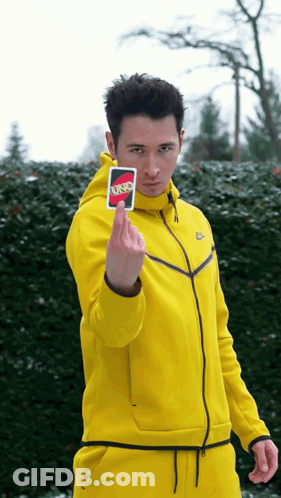 A Man In A Yellow Jacket Is Holding A Uno Card GIF