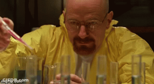 A Man In A Yellow Jacket Is Pouring Liquid Into Beakers GIF