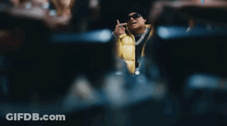 A Man In A Yellow Jacket Is Sitting At A Table With A Bunch Of People Holding Money . GIF