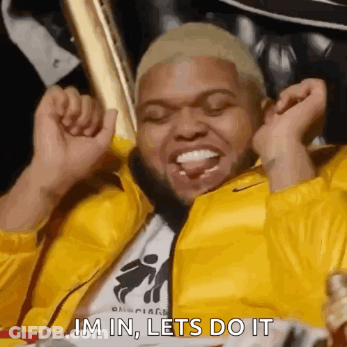 A Man In A Yellow Jacket Is Sitting In A Chair With His Arms In The Air And The Words Im In Lets Do It . GIF
