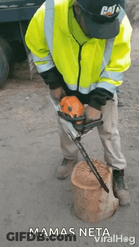 A Man In A Yellow Jacket Is Using A Chainsaw To Cut A Log . GIF