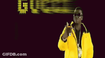 A Man In A Yellow Jacket Stands In Front Of A Sign That Says Dice GIF