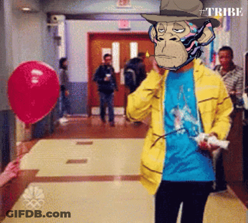 A Man In A Yellow Jacket With A Monkey On His Face Holding A Remote Control GIF
