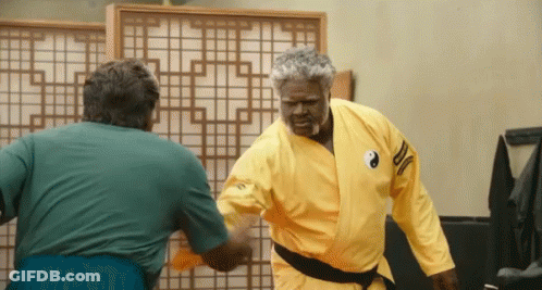 A Man In A Yellow Karate Uniform Has A Yin Yang Symbol On His Shoulder GIF