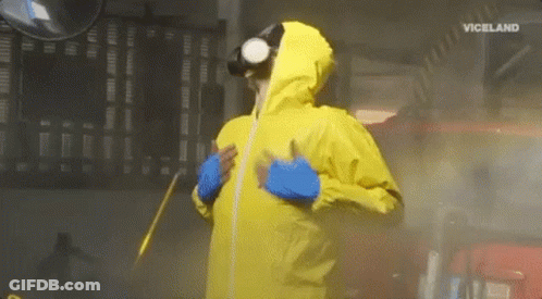 A Man In A Yellow Protective Suit Is Spraying A Car With A Spray Gun . GIF
