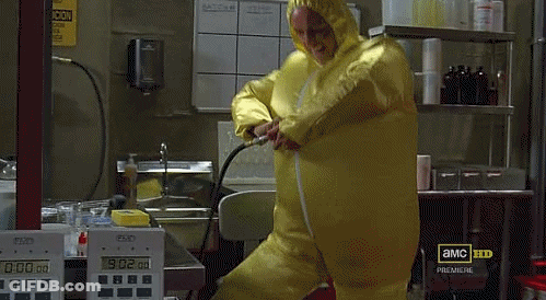 A Man In A Yellow Protective Suit Is Standing In Front Of A Display That Says 0:02 GIF