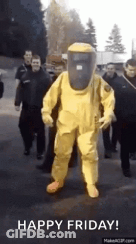 A Man In A Yellow Protective Suit Is Walking Down The Street . GIF