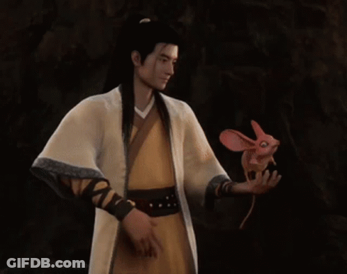 A Man In A Yellow Robe Is Holding A Pink Fish In His Hand GIF