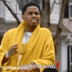 A Man In A Yellow Robe Is Saying `` Good Evening '' While Holding A Cup Of Coffee . GIF