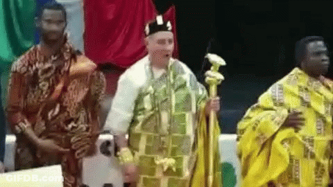 A Man In A Yellow Robe Is Standing Next To Two Other Men In Traditional Clothing . GIF