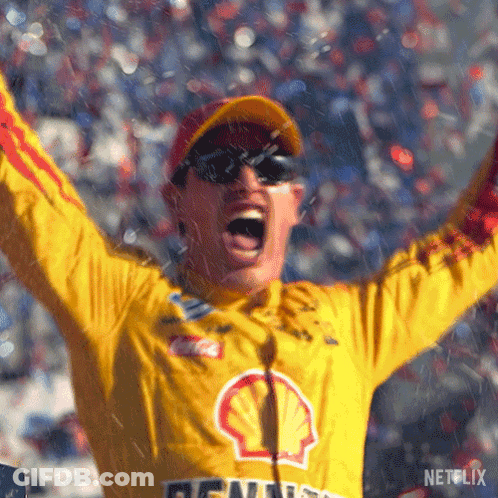 A Man In A Yellow Shell Jacket Is Raising His Arms In The Air GIF