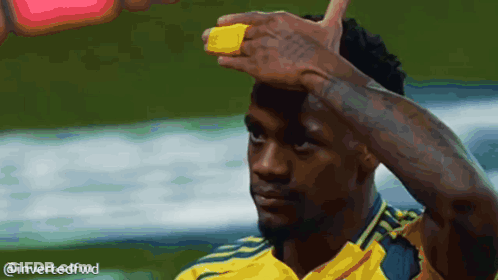 A Man In A Yellow Shirt Has A Yellow Band On His Forehead GIF