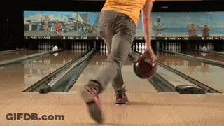 A Man In A Yellow Shirt Is Bowling On A Bowling Alley GIF