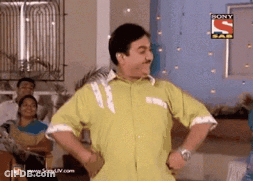 A Man In A Yellow Shirt Is Dancing In Front Of A Sign That Says Sony GIF