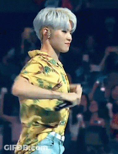 A Man In A Yellow Shirt Is Dancing On A Stage In Front Of A Crowd GIF