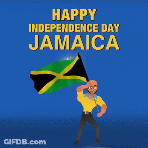 A Man In A Yellow Shirt Is Holding A Jamaican Flag In Front Of A Fireworks Display That Says Happy Independence Day Jama GIF