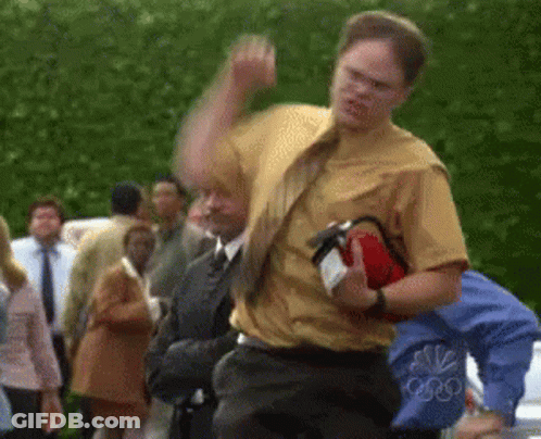A Man In A Yellow Shirt Is Holding A Red Fire Extinguisher GIF