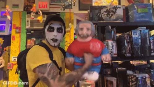 A Man In A Yellow Shirt Is Holding A Stuffed Superman Figure GIF