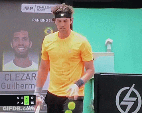 A Man In A Yellow Shirt Is Holding A Tennis Racquet In Front Of A Scoreboard That Says Clezar Guilherme GIF