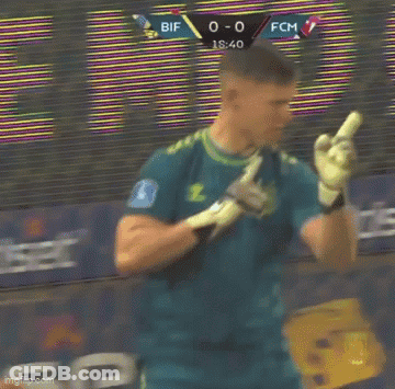 A Man In A Yellow Shirt Is Holding Another Man 'S Hand In Front Of A Soccer Net . GIF