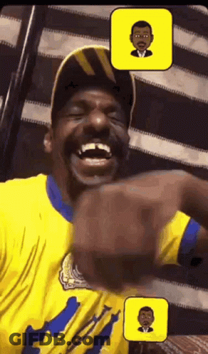 A Man In A Yellow Shirt Is Laughing With A Picture Of A Man In A Suit Behind Him GIF