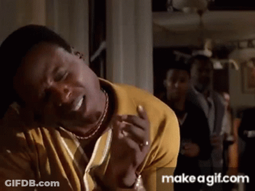 A Man In A Yellow Shirt Is Making A Funny Face With His Eyes Closed GIF