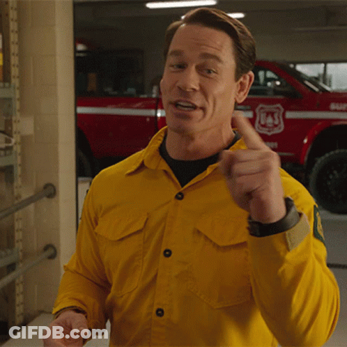 A Man In A Yellow Shirt Is Pointing At Something In Front Of A Red Truck That Says Usf GIF